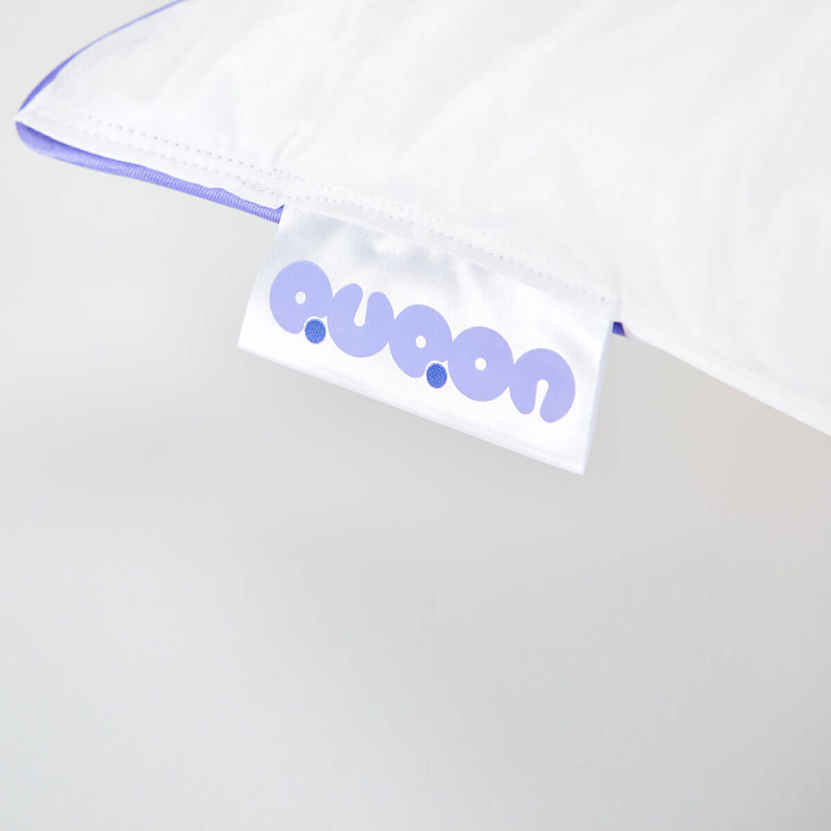 Close-up of the QUQON Daunenkissen Nordic pillow label, showcasing craftsmanship and quality, made in Germany.