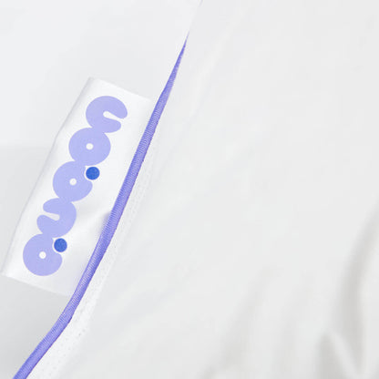 Close-up of Daunenkissen Nordic.Trio pillow edge with QUQON logo and purple trim, highlighting quality craftsmanship.
