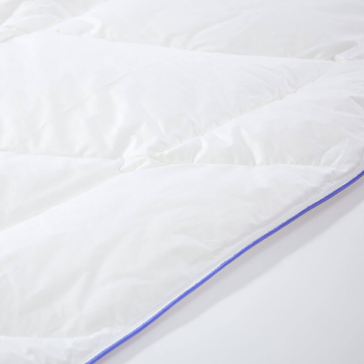 Luxurious white Daunendecke De Luxe duvet with premium Austrian goose down filling, featuring blue edging for ultimate comfort.